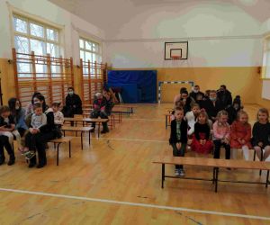 Przedszkolaki z rodzicami na ławkach