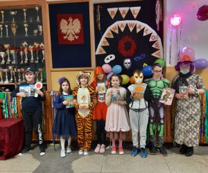 Uczniowie klasy czwartej w strojach karnawałowych z opiekunem SU