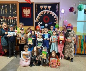 Uczniowie klas 1-4 z paniami organizującymi bal karnawałowy z książką