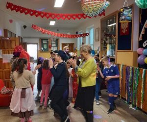 Uczniowie z nauczycielkami tańczą w kółeczku