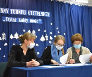 Osoby siedzą wewnątrz budynku.