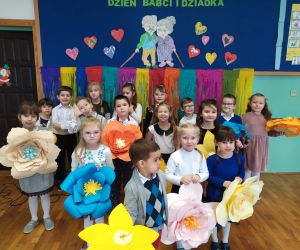 dzieci stoją z kwiatkami