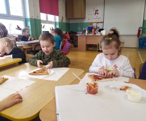 dzieci jedzą pizzę