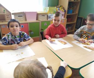 chłopcy jedzą pizzę