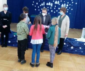 Chłopiec i dwie dziewczynki odbierają nagrody od mężczyzny i dwóch kobiet