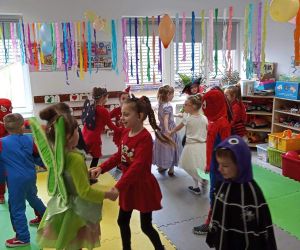 Przedszkolaki tańczą w przystrojonej sali przedszkolnej