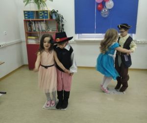 Pierwszoklasiści tańczą parami na gazetach