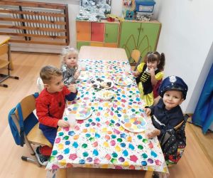 Przedszkolaki w strojach karnawałowych podczas poczęstunku
