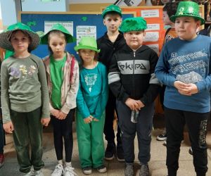 Uczniowie w zielonych nakryciach głowy