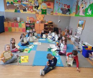 Przedszkolaki siedzą w kręgu. Trzymają w rękach dyplomy
