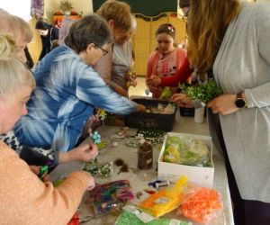 Osoby wykonują ozdoby wielkanocne podczas warsztatów