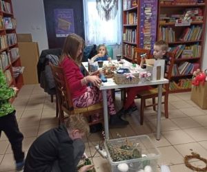 Osoby wykonują ozdoby wielkanocne podczas warsztatów