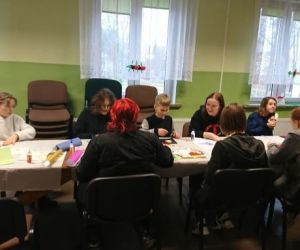 Osoby wykonują ozdoby wielkanocne podczas warsztatów