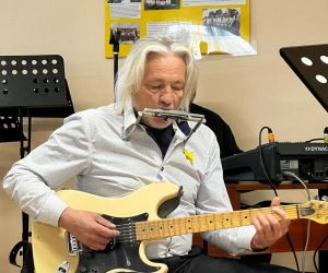 Osoba wewnątrz budynku gra na gitarze