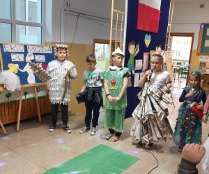 Uczennica w stroju wykonanym z papierowych rożków mówi wiersz