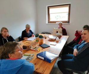 Kobiety wewnątrz budynku, siedzą przy stole.