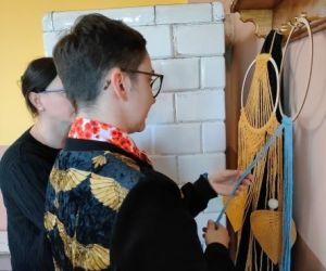 Kobiety zaplatają makramę.