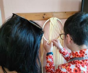 Kobiety zaplatają makramę.