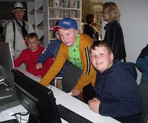 Uczniowie wraz z przewodnikiem i opiekunem oglądają zasoby w części cyfrowej biblioteki w Świdniku