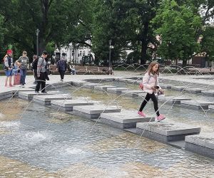 Uczniowie spacerują przy fontannach na placu Litewskim