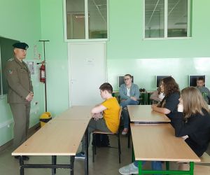 Przedstawiciel Wojska Polskiego opowiada uczniom o swojej pracy, uczniowie słuchają i zadają pytania
