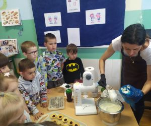 Cukiernik nakłada masę do rękawa cukierniczego