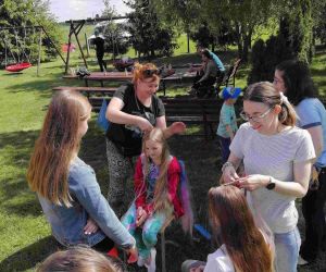 Mamy zaplatają kolorowe warkoczyki.