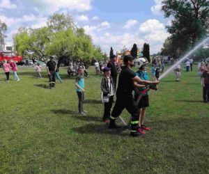 Uczeń z wężem gaśniczym w obecności strażaka.