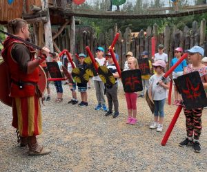Uczniowie z tarczami i pałkami podczas szkolenia rycerskiego