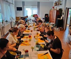 Grupa osób podczas warsztatów, wewnątrz budynku.