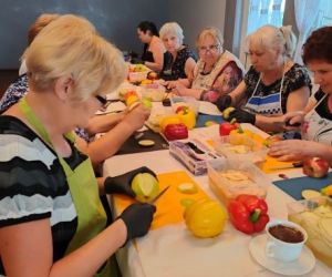 Grupa osób podczas warsztatów, wewnątrz budynku.