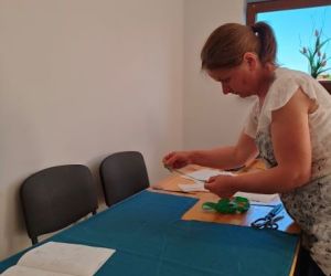 Osoba wykraja ubrania ze wzornika podczas warsztatów z szycia ubrań w stylu BOHO.