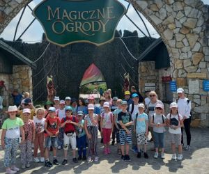 Uczniowie z wychowawcą stoją przy wejściu do Magicznych Ogrodów