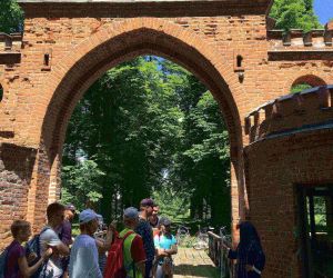 Grupa młodzieży w bramie parkowej.