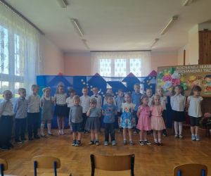 DZIECI W STROJACH GALOWYCH  RECYTUJĄ WIERSZE Z OKAZJI DNIA MAMY I TATY