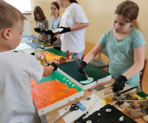 Grupa osób podczas warsztatów plastycznych.