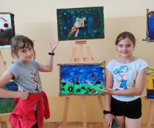 Uczestnicy warsztatów ze swoimi obrazami.