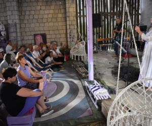 Występ osoby i publiczność wewnątrz budynku.