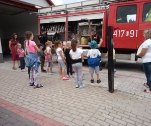 Zdjęcie przedstawia grupę dzieci oglądającą wóz strażacki.