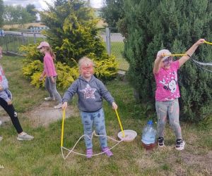 Na zdjęciu widoczne są dzieci robiące bańki na świeżym powietrzu.