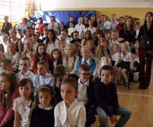 Uczniowie i ich rodzice w sali gimnastycznej podczas uroczystości