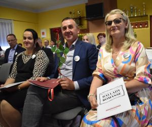 Na zdjęciu widoczna jest grupa osób siedząca na krzesłach wewnątrz budynku.
