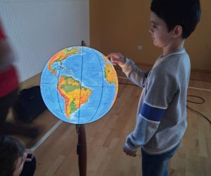 Uczeń przy podświetlanym globusie