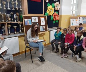 Uczennica w szarej bluzie czyta wybraną książkę