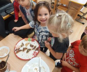 Dziewczynki częstują się przekąskami z talerza