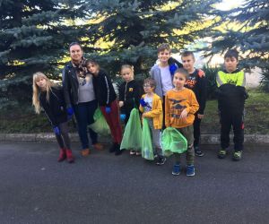 Uczniowie klasy III z nauczycielką z workami śmieci zebranymi na terenie wokół szkoły