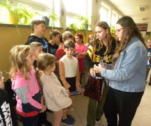 Dziewczyny  rozdają słodki upominek chłopcom