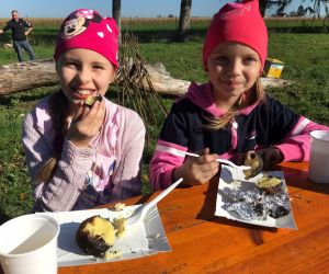 Dwie dziewczynki jedzą pieczone ziemniaki