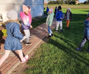 Uczniowie zbierają śmieci na terenie szkoły.