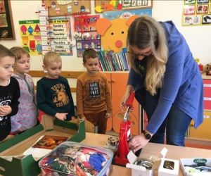 Pani z GOK wykonuje przypinki dla dzieci